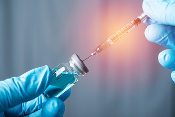 doctor or science hand holding blue vaccine bottle