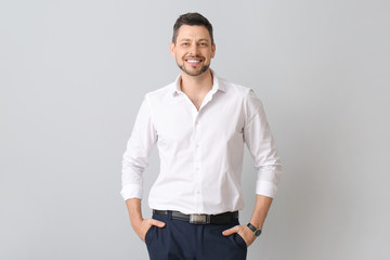 Fototapeta premium Portrait of handsome businessman on light background