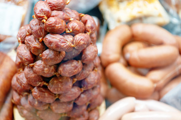 A bunch of small smoked sausages. Butcher shop window.