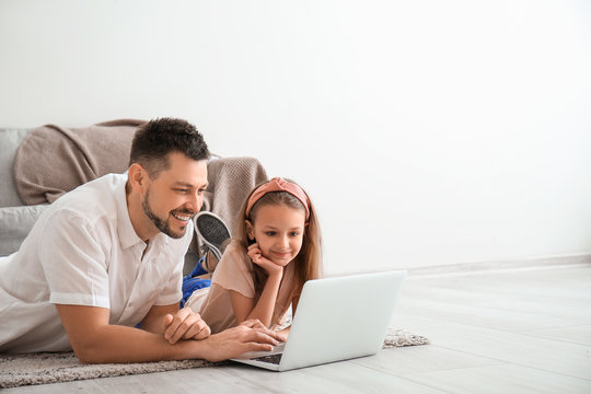 Father with little daughter video chatting at home