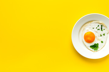 Fried eggs on plate - yellow dinner table from above copy space