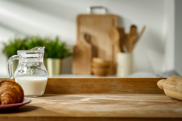 Wooden table in the kitchen with incoming morning sunlight with free space for an advertising product