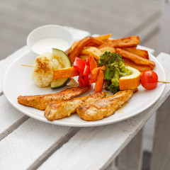 Szaszłyk, grilowany kurczak, warzywa i frytki, smaczny obiad lub lunch.