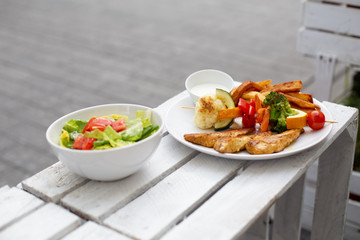 Szaszłyk, grilowany kurczak, warzywa i frytki, smaczny obiad lub lunch.