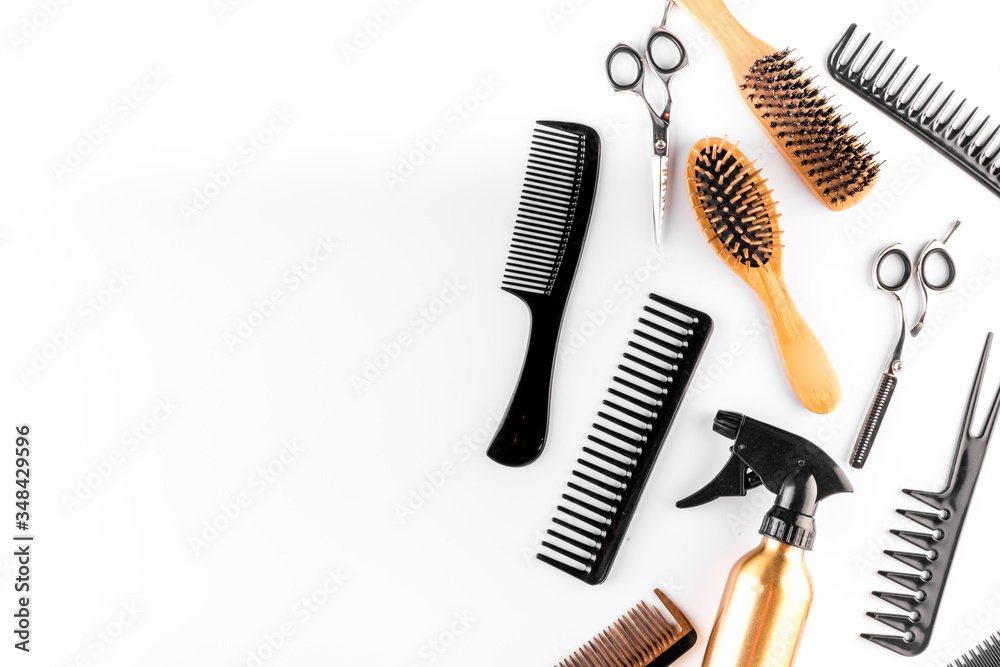 Wall mural Hairdressing instruments. Combs, scissors and spray on white desk from above frame space for text