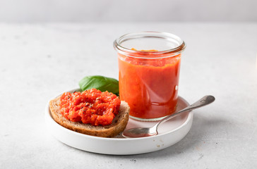 Balkan traditional dish ajvar in a glass on a light background.