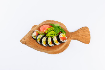 Rolki sushi na drewnianym talerzu w kształcie ryby.