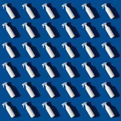 Blank cleaning spray bottle on bluebackground pattern. Flat lay, top view.