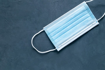 Close-up medical mask against a dark background. A symbol of a pandemic, the protection of the...