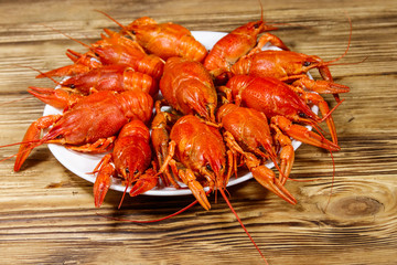 Boiled crayfish in plate on wooden table