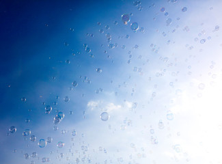 Soap bubbles fly in the blue sky