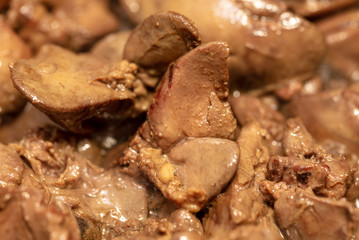 Chicken liver is fried in a pan.