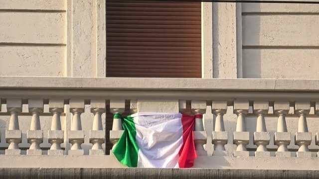 close up of Italian flag at the balcony in Italy for covid-19 dead memorial and mourning during quarantine lockdown.