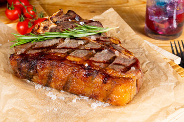 Grilled steak with vegetables, sea salt, rosemary and spices served on the restaurant table