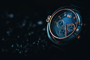 Metallic gold Phantom Blue men's watch on a black background. 