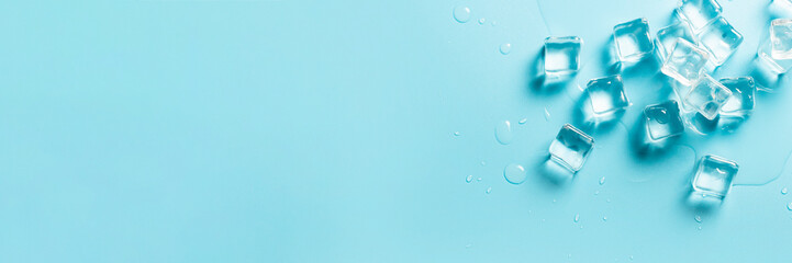 Ice cubes with water on a blue background. Ice concept for drinks. Banner. Flat lay, top view
