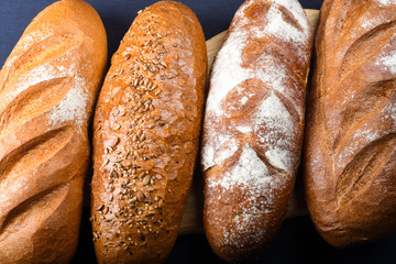 Many mixed breads and rolls shot from above. Top view of assortment of different cereal bakery