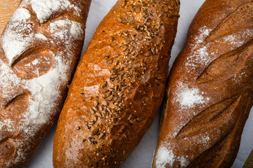 Many mixed breads and rolls shot from above. Top view of assortment of different cereal bakery