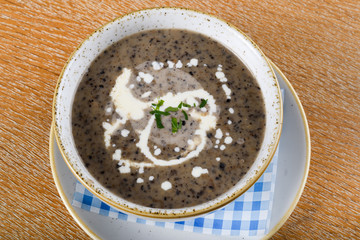 Mushroom cream soup. Chanterelle cream soup on wooden background, selective focus