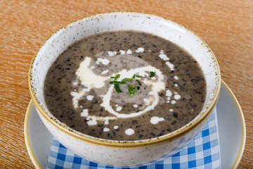 Mushroom cream soup. Chanterelle cream soup on wooden background, selective focus