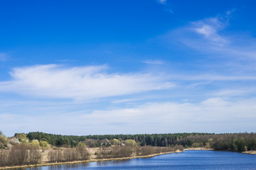 blue river with trees against the blue sky