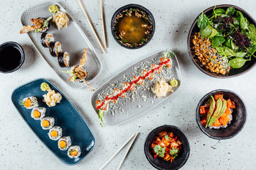 Japanese Food table with sushi rolls, chicken, rice and vegetables. Asian Dinner Table.