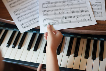 Close-up of a child's hand playing the piano . Favorite classical music. musical instruments for...