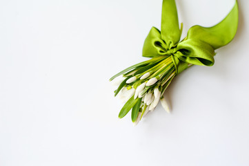 spring white flowers tied up in satin ribbon on white background. A place to insert text against a white background. Selective focus.