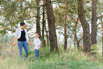 Fototapeta premium Happy family! Mother with son child playing having fun together on the grass in sunny summer day, life moment