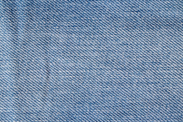 Denim background texture. Close-up of details of empty light blue jeans fabric jean surface. Macro....