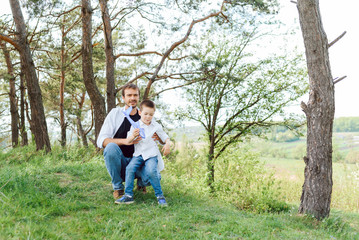 Fototapeta premium father and son have fun together in nature. Father and son playing. People having fun outdoors. Concept of friendly family.