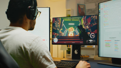 Zoom in shot of caucasian gamer playing shooter game in live competition, talking and streaming at...