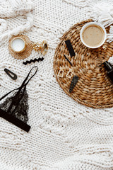 Flat lay fashionable female underwear, clothes and accessories. Black bra, perfume, earrings on blanket. Top view fashion lifestyle beauty collage