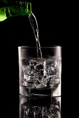 Glass of mineral water on black background