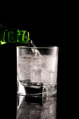 Glass of mineral water on black background