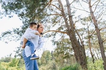 Stilish mother and handsome son having fun on the nature. Happy family concept. Beauty nature scene with family outdoor lifestyle. Happy family resting together. Happiness in family life. Mothers day.