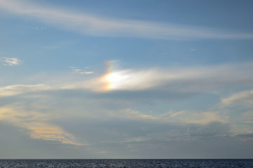 Obraz premium rare optical phenomenon, especially in mid-summer: sun dog (parhelia) produced by the reflection and refraction of sunlight through ice crystals - Therma beach, Samothraki island, Greece, Aegean sea