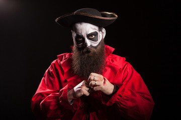 Bearded man disguised as a dangerous pirate over black background.