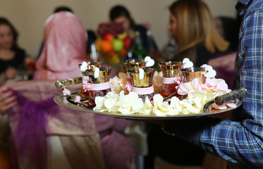 armudu cups . Armudu cups for the engagement ceremony . Boy holding silver salver . tea in eastern armudu glass on the silver salver on the white tablecloth, Arabic, Turkish, Azerbaijani customs .