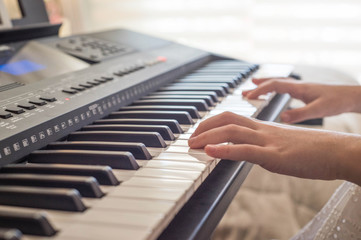 Fototapeta na wymiar Distance education. Pretty young musician playing classic digital piano at home during online class at home, social distance during quarantine, self-isolation, online education concept