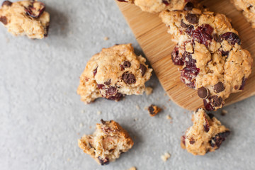 Fresh organic homemade cookies with chocolate chips and dried berries on wooden board on table
