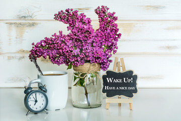 Bouquet of Purple Lilac with Cup of Coffee and Wake Up,Have a Nice Day  Text on  Wooden Background .Spring Morning Concept 