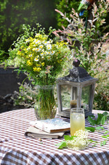 Elderberry Lemonade on a Table with Bouquet of Wild Flowers and Wooden Lantern