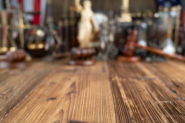 Lawyers office concept. Law symbols composition - gavel and Themis statue on rustic wooden desk.