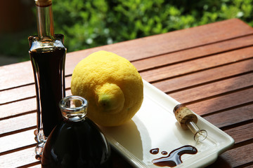 Aceto balsamico tipico di Modena, primo piano in abbinamento con limoni su un tavolo all’aperto