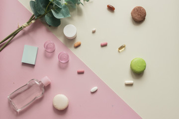 A close-up top view of various pills and macaronis on pink and yellow background. Medical, pharmacy and health care concept. Copy place for text or logo. Dietary supplements and vitamins. Top view