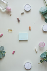 A close-up top view of various pills, capsules, tablets, blue sticker and pill box on white background. Dietary supplements and vitamins. Copy place for text or logo. Medical, pharmacy and health care