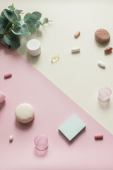 A close-up view of various pills and macaroni on pink and yellow background. Dietary supplements and vitamins. Medical, pharmacy and health care concept. Empty place for text or logo. Top down view.