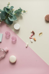 A close-up top view of various pills and macaroni on yellow and pink background. Dietary supplements and vitamins. Medical, pharmacy and health care concept. Copy place for text or logo. Pill box.