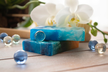 Sea salt, natural soap and orchid flower on wooden background. Aroma spa set